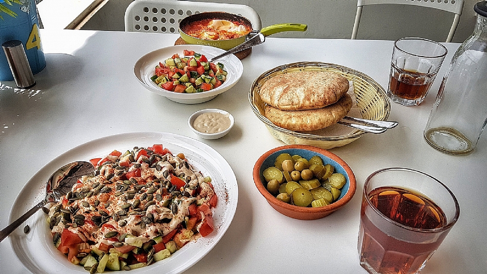 פלאפל חם מוגש יחד עם פיתה, טחינה וחמוצים